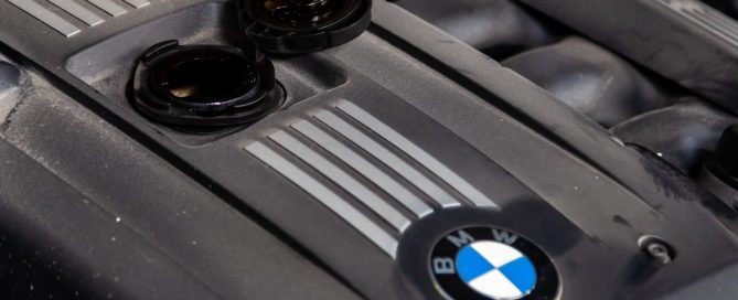 BMW engine cover with oil cap removed, ready for oil change.