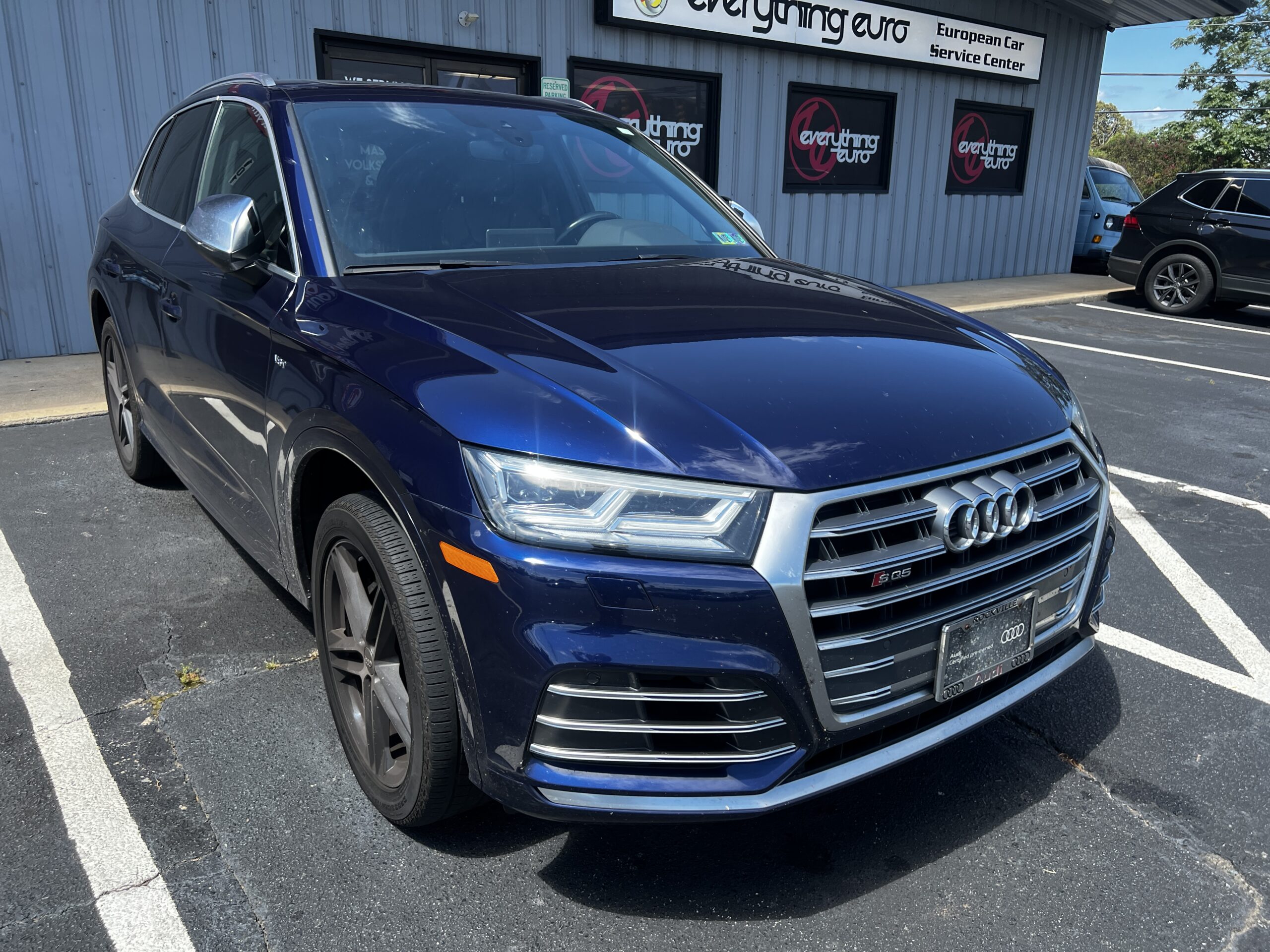 Dark blue Audi SQ5 parked outside Everything Euro European car repair shop.