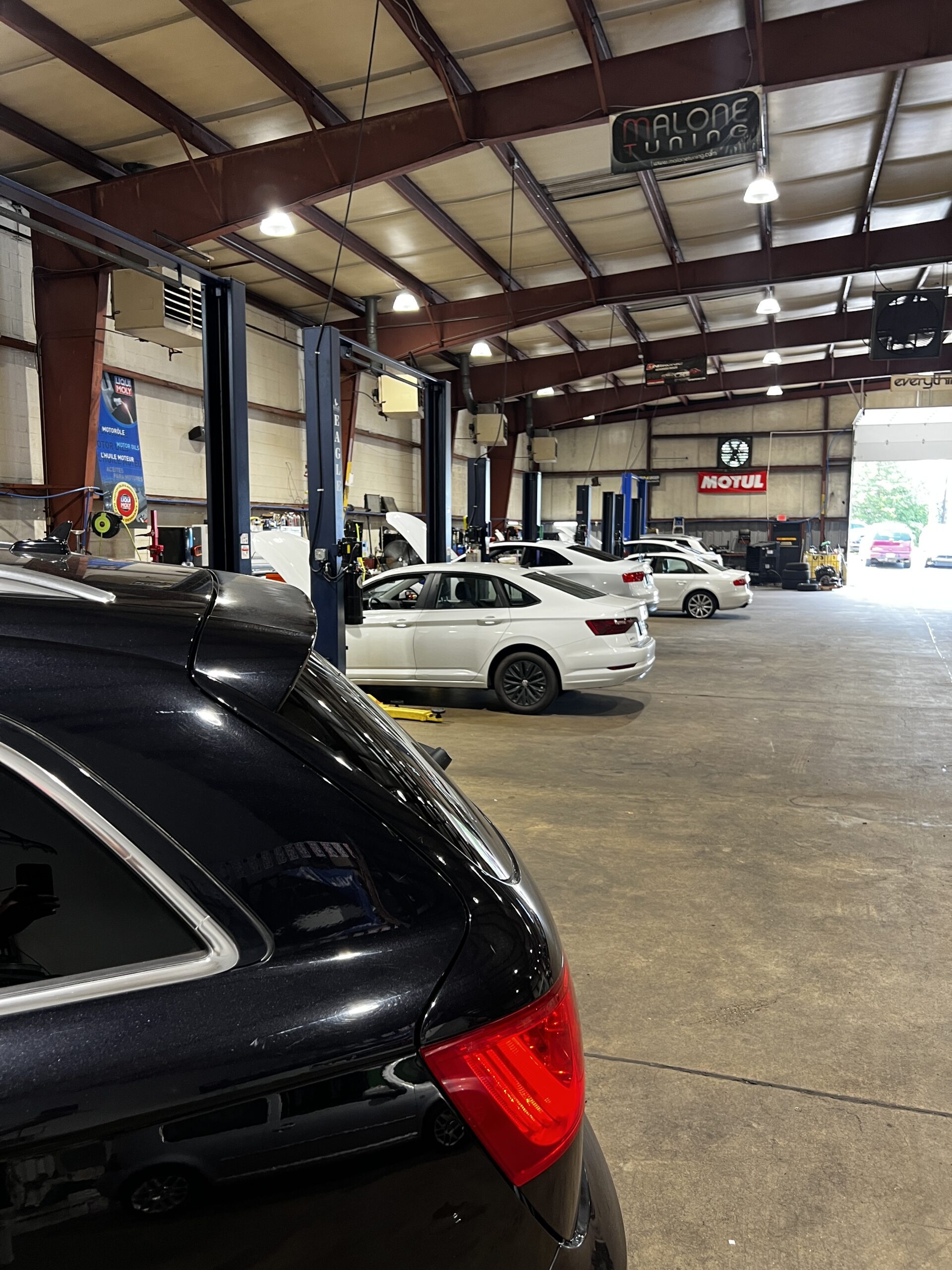 Malone Tuning Euro repair shop with cars on lifts and bays open.