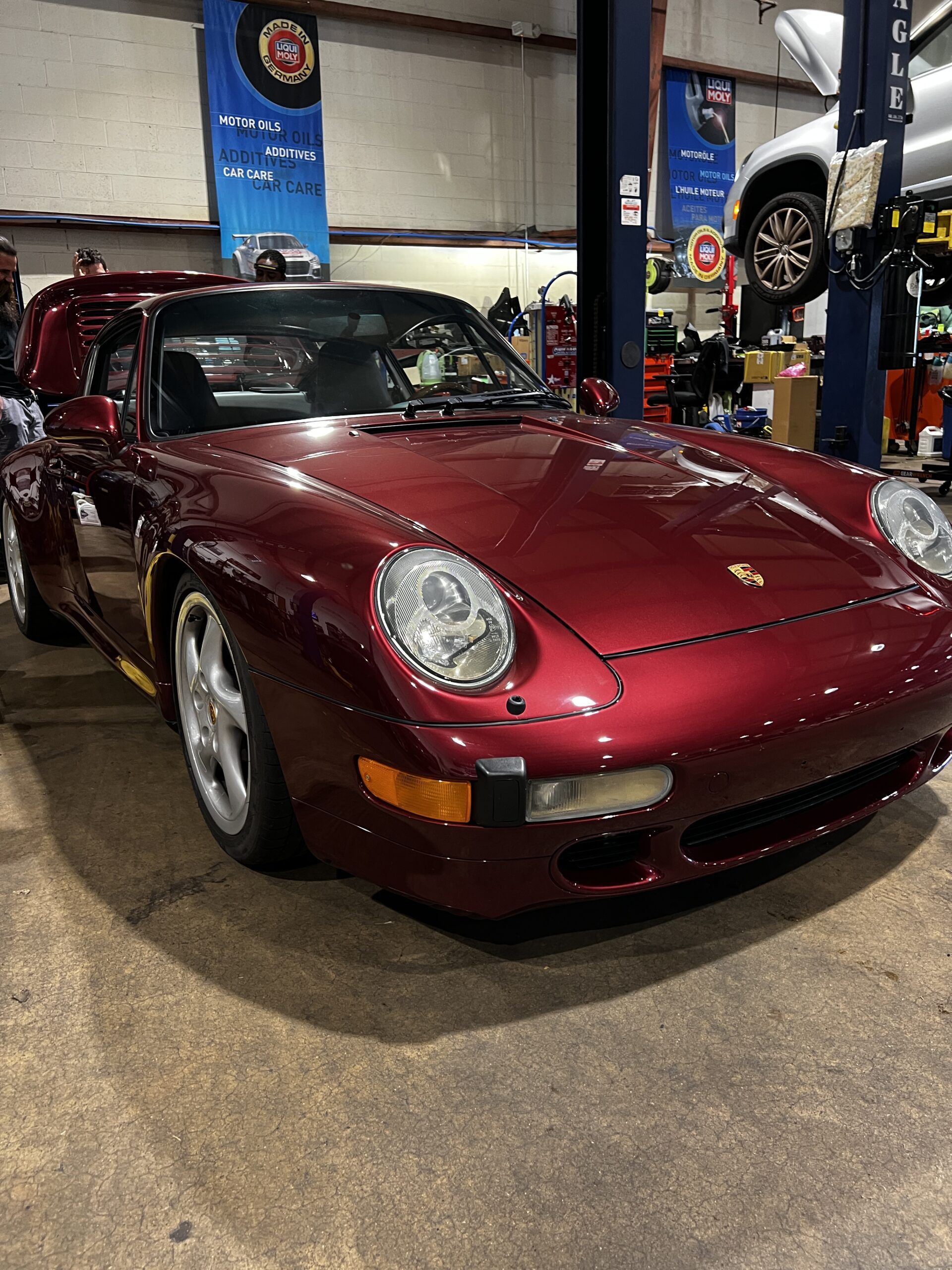 Red Porsche 911 at Euro repair shop, ready for service.