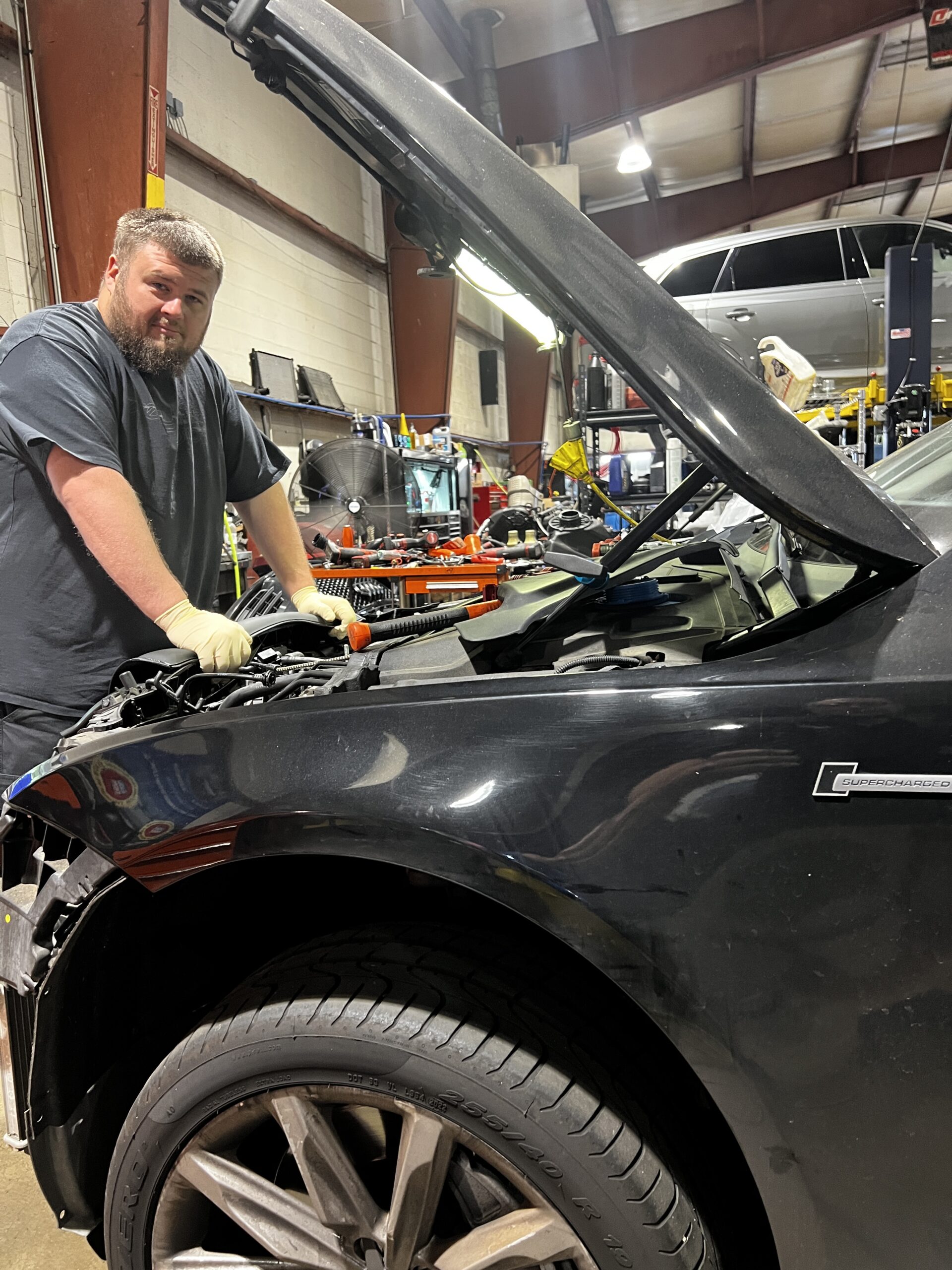 Mechanic working on a black Audi Supercharged at Everything Euro Repair Shop.