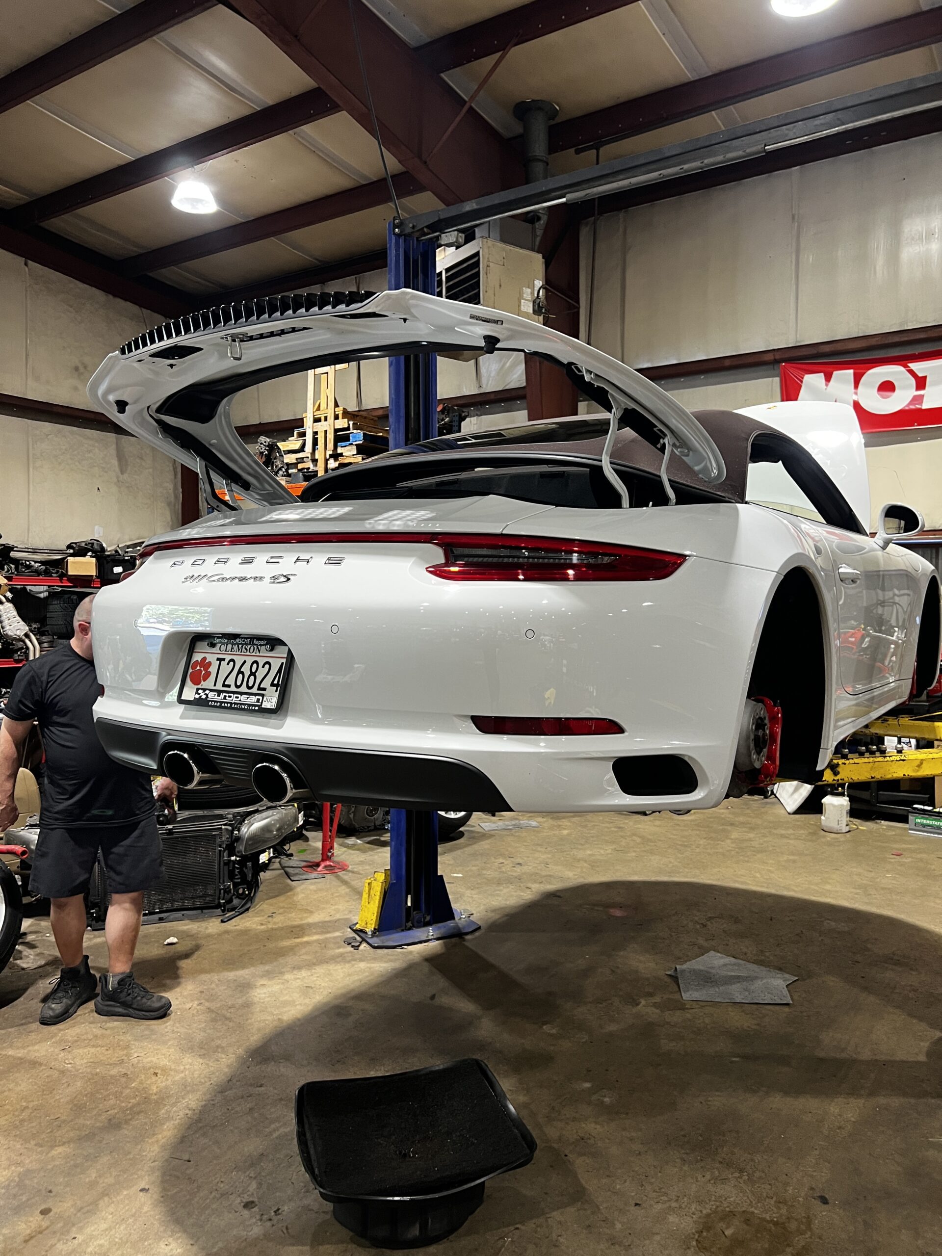 White Porsche 911 Carrera S on a lift at Everything Euro Repair Shop