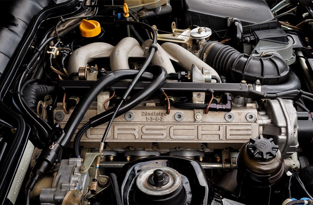 Porsche engine with "Zündfolge 1-3-4-2" text, relevant to rough idle issues.